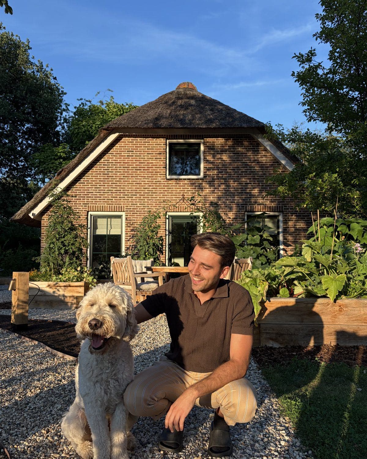 Guido Postma met hond Bobbie voor de rietgedekte boerderij aan de Wandelbosweg in Havelte